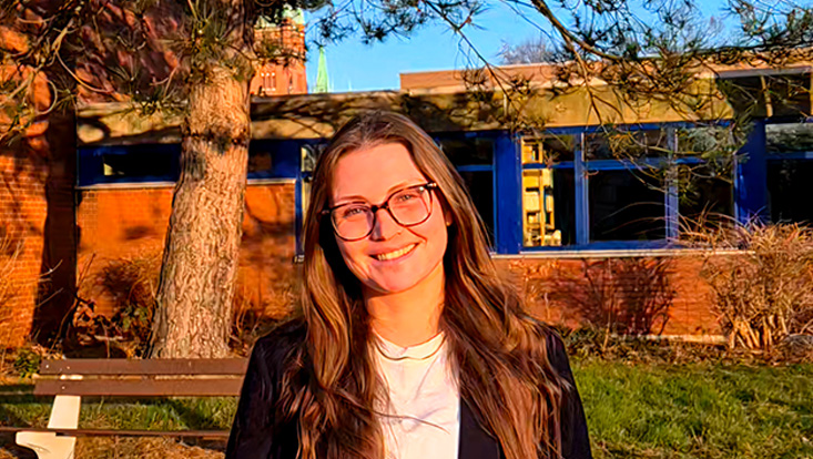 Portrait von Frau vor Gebäude mit blauem Himmel