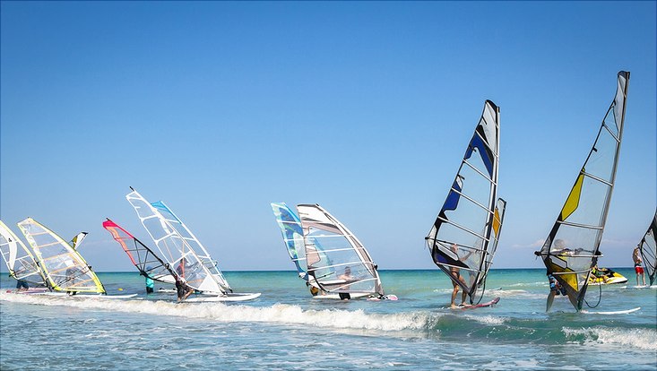 Gruppe von Windsurfern in blauem Meer